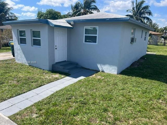 126 NW 13th Ave, Dania Beach, FL 33004 - view of front of home with stucco siding and a front lawn