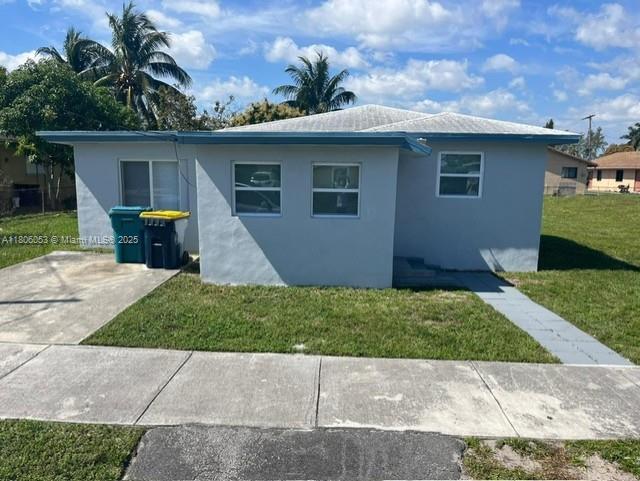 126 NW 13th Ave, Dania Beach, FL 33004 - view of side of home featuring a lawn and stucco siding