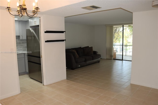 3730 Inverrary Dr Unit 2Y, Lauderhill, FL 33319 - living area with a chandelier, light tile patterned floors, baseboards, and a textured ceiling
