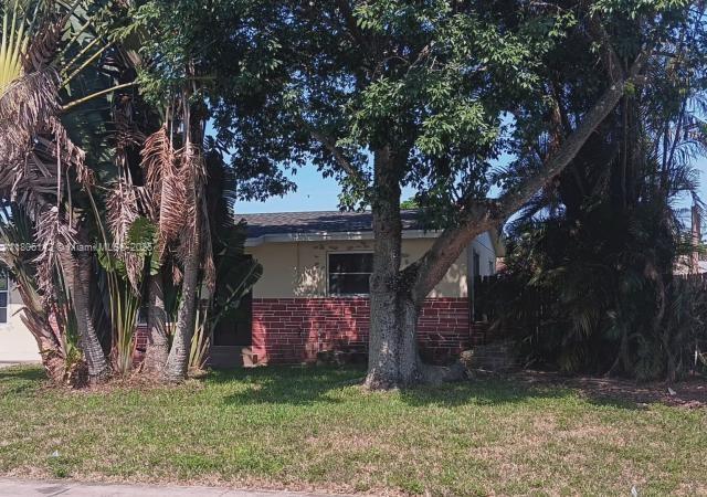 view of side of home with brick siding and a lawn