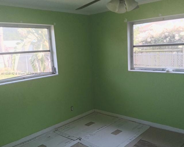 spare room featuring baseboards and ceiling fan