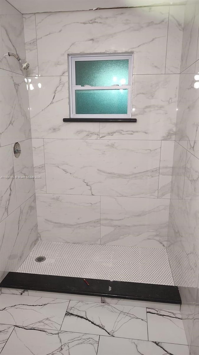 884 Montego Dr, West Palm Beach, FL 33415 - bathroom featuring tiled shower and marble look tiles