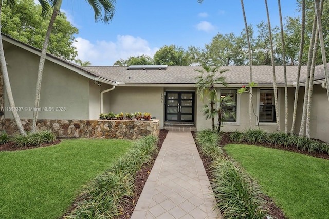 7935 SW 155th St, Palmetto Bay, FL 33157 - property entrance featuring stucco siding, a lawn, solar panels, and a shingled roof