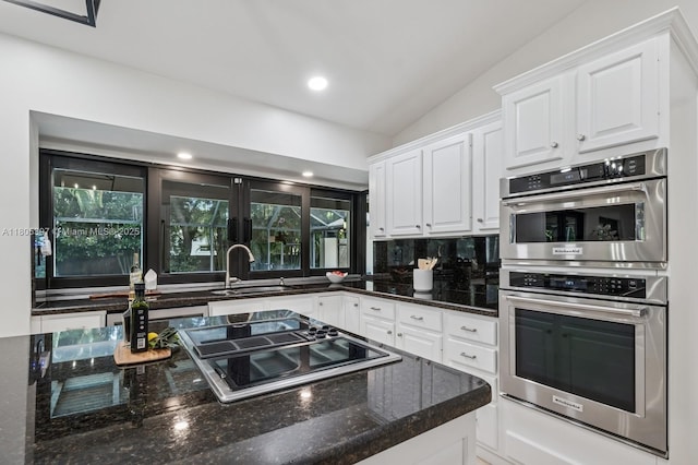 7935 SW 155th St, Palmetto Bay, FL 33157 - kitchen with stainless steel double oven, a sink, white cabinets, dark stone countertops, and black electric cooktop