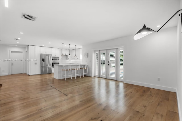 living area featuring light wood finished floors, baseboards, and recessed lighting