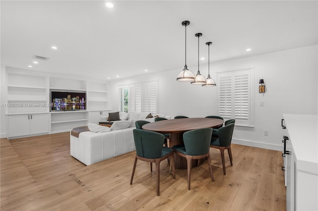 dining area featuring light wood-style flooring, recessed lighting, baseboards, and built in shelves
