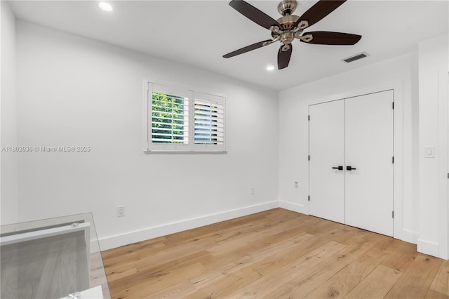 unfurnished bedroom featuring light wood finished floors, recessed lighting, baseboards, a ceiling fan, and a closet