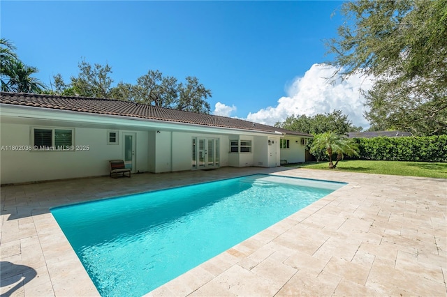 view of pool with french doors and a patio area