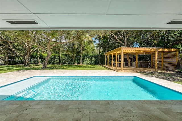 swimming pool featuring a pergola, view of scattered trees, a lawn, and a patio area