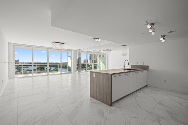 400 Sunny Isles Blvd Unit 1005, Sunny Isles Beach, FL 33160 - kitchen with expansive windows, light marble finish flooring, open floor plan, a sink, and a peninsula