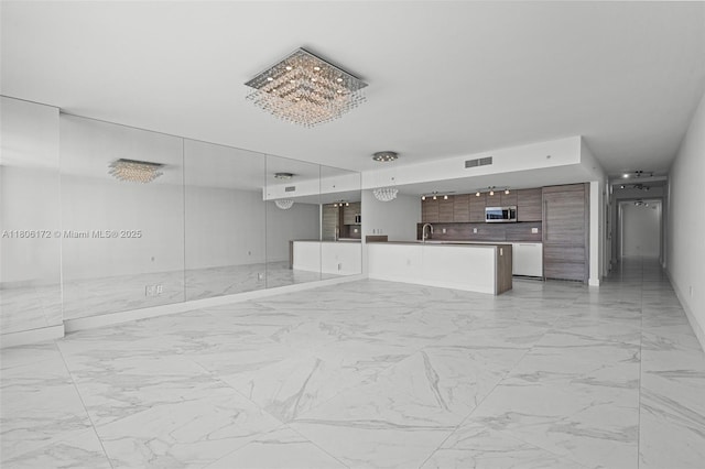 400 Sunny Isles Blvd Unit 1005, Sunny Isles Beach, FL 33160 - unfurnished living room featuring light marble finish floors, a chandelier, a sink, and baseboards