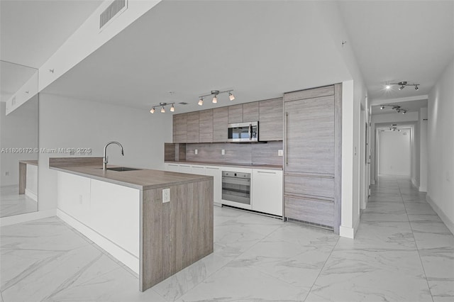 400 Sunny Isles Blvd Unit 1005, Sunny Isles Beach, FL 33160 - kitchen with stainless steel appliances, light marble finish floors, and rail lighting