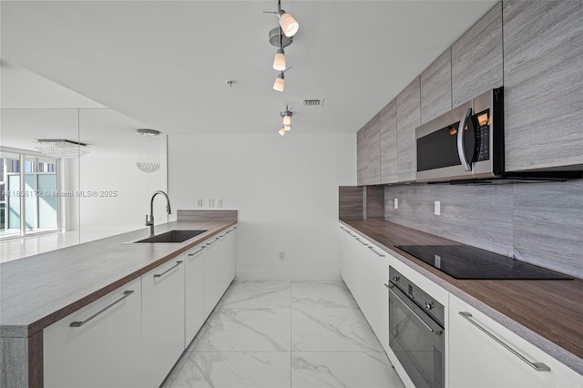 400 Sunny Isles Blvd Unit 1005, Sunny Isles Beach, FL 33160 - kitchen featuring a sink, wall oven, black electric cooktop, stainless steel microwave, and light marble finish floors