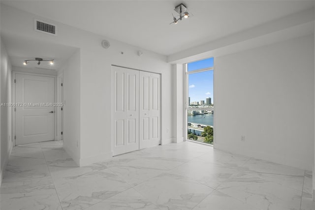 400 Sunny Isles Blvd Unit 1005, Sunny Isles Beach, FL 33160 - unfurnished bedroom featuring marble look tile flooring, multiple windows, and baseboards