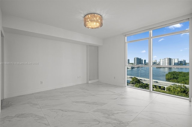 400 Sunny Isles Blvd Unit 1005, Sunny Isles Beach, FL 33160 - spare room featuring expansive windows, marble look tiles, baseboards, and a view of skyline