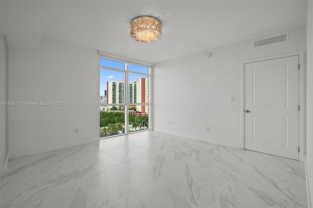 400 Sunny Isles Blvd Unit 1005, Sunny Isles Beach, FL 33160 - unfurnished room featuring a wall of windows, marble look tiles, a city view, and baseboards