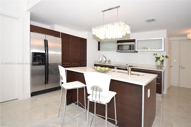 1900 N Bayshore Dr Unit 2804, Miami, FL 33132 - kitchen with appliances with stainless steel finishes, dark brown cabinetry, a kitchen bar, and light countertops