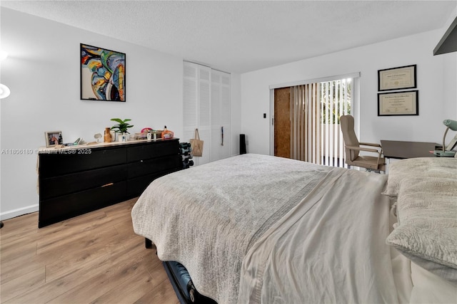 bedroom with light wood finished floors and a textured ceiling
