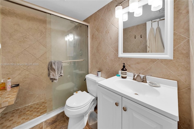 bathroom featuring tile walls, a shower stall, vanity, and toilet