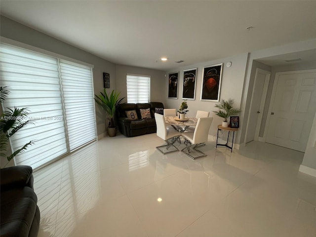 tiled dining area with baseboards and recessed lighting