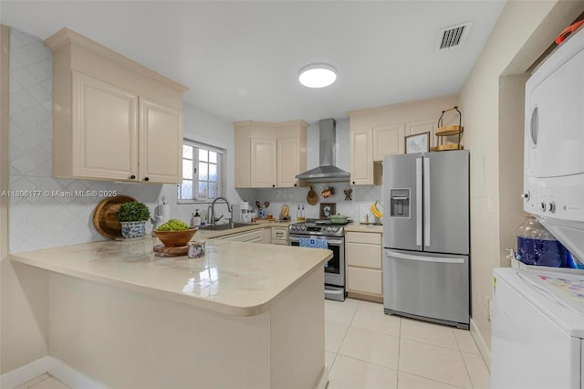 11429 NW 93rd Ct Unit 1, Hialeah Gardens, FL 33018 - kitchen with stainless steel appliances, wall chimney range hood, stacked washer / drying machine, a sink, and a peninsula