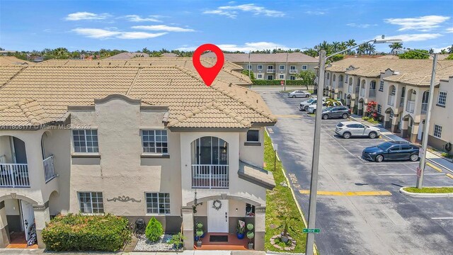 11429 NW 93rd Ct Unit 1, Hialeah Gardens, FL 33018 - exterior view of stucco siding, parking, a tile roof, and a residential view