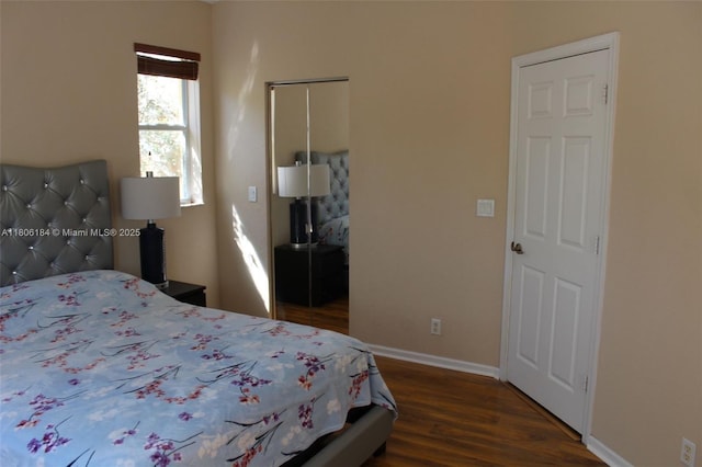 bedroom featuring a closet, baseboards, and wood finished floors