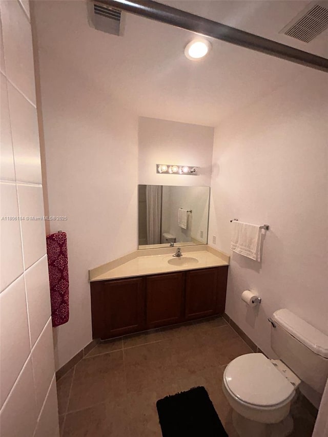 bathroom featuring toilet, vanity, recessed lighting, baseboards, and tile patterned flooring