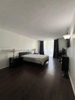 801 Three Islands Blvd Unit 112, Hallandale Beach, FL 33009 - bedroom featuring dark wood finished floors, baseboards, and a textured ceiling