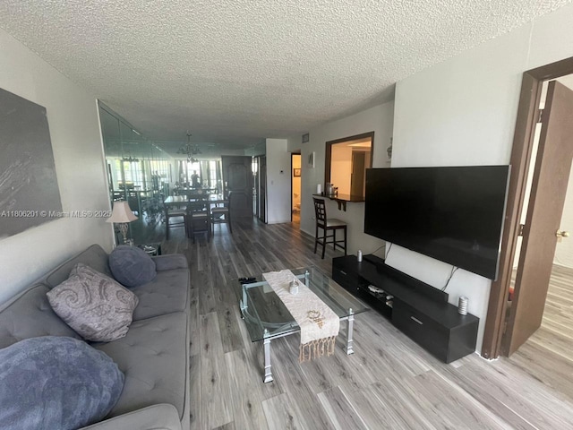 801 Three Islands Blvd Unit 112, Hallandale Beach, FL 33009 - living area with wood finished floors, a textured ceiling, and a chandelier