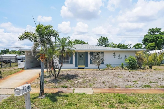 330 Lasayette Dr NE, Port Charlotte, FL 33952 - view of front of home with concrete driveway, fence, and an attached carport