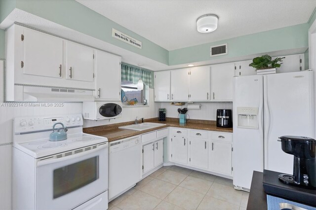 330 Lasayette Dr NE, Port Charlotte, FL 33952 - kitchen featuring white appliances, a sink, under cabinet range hood, and white cabinetry