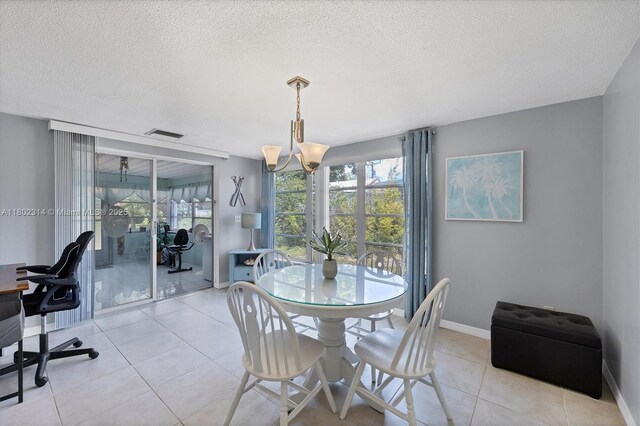 330 Lasayette Dr NE, Port Charlotte, FL 33952 - dining area with a textured ceiling, a chandelier, light tile patterned flooring, and baseboards
