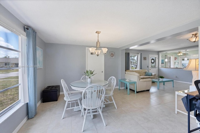 330 Lasayette Dr NE, Port Charlotte, FL 33952 - dining space featuring a chandelier, light tile patterned floors, baseboards, ceiling fan, and a textured ceiling