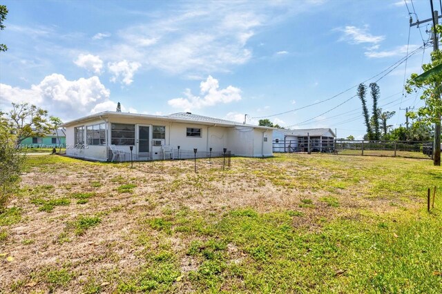 330 Lasayette Dr NE, Port Charlotte, FL 33952 - rear view of property featuring a sunroom and fence