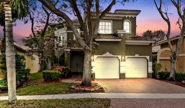 5764 NW 125th Ter, Coral Springs, FL 33076 - mediterranean / spanish-style house with stucco siding, a tile roof, decorative driveway, and an attached garage