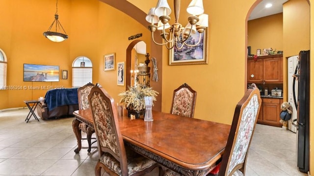 5764 NW 125th Ter, Coral Springs, FL 33076 - dining area with arched walkways, a chandelier, light tile patterned floors, and a high ceiling