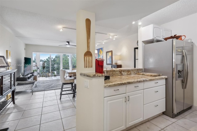 3050 NE 47th Ct Unit 205, Fort Lauderdale, FL 33308 - kitchen with stainless steel refrigerator with ice dispenser, track lighting, open floor plan, white cabinetry, and light tile patterned flooring