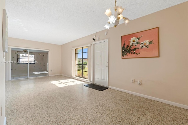 4295 SW 97th Ct, Miami, FL 33165 - foyer featuring a chandelier, plenty of natural light, speckle patterned floor, a textured ceiling, and baseboards