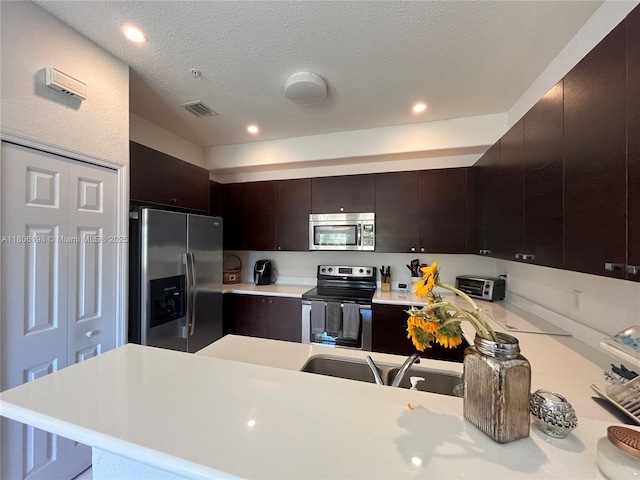 10012 NW 7th St Unit 203, Miami, FL 33172 - kitchen featuring appliances with stainless steel finishes, light countertops, a sink, recessed lighting, and a textured ceiling