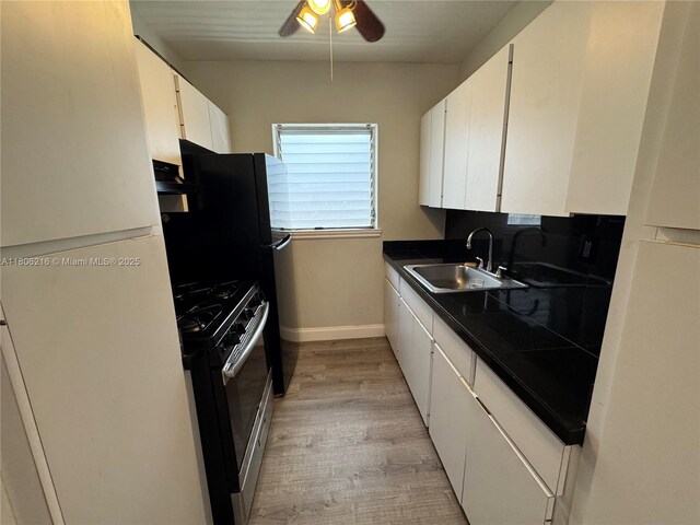 75 Washington Ave Unit 18, Miami Beach, FL 33139 - kitchen with a sink, gas stove, a ceiling fan, white cabinetry, and light wood-style floors
