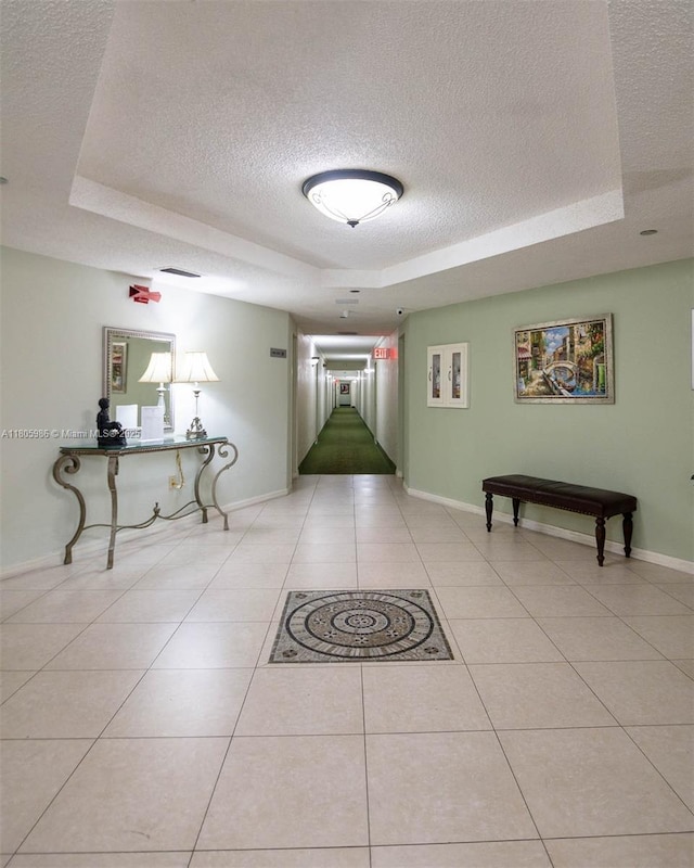 900 Saint Charles Pl Unit 616, Pembroke Pines, FL 33026 - corridor featuring a tray ceiling, a textured ceiling, baseboards, and light tile patterned flooring