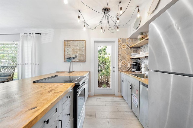 1411 NE 12th St, Fort Lauderdale, FL 33304 - kitchen featuring appliances with stainless steel finishes, butcher block countertops, open shelves, and healthy amount of natural light