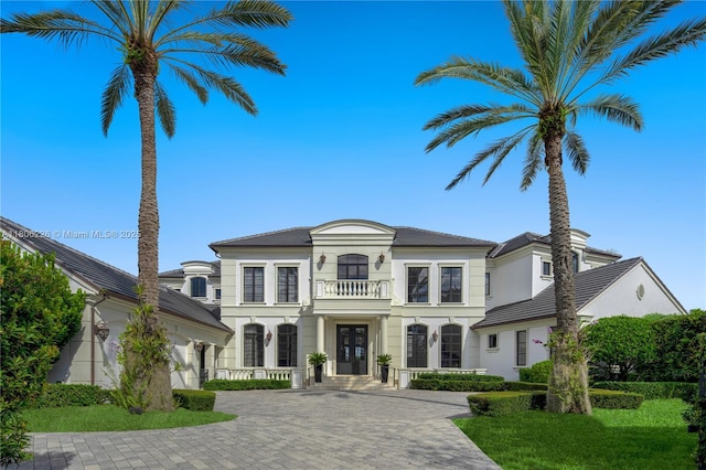 9320 Gallardo St, Coral Gables, FL 33156 - french country style house with a balcony, stucco siding, decorative driveway, french doors, and covered porch