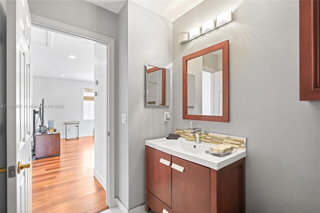 1282 Grant Ct, Hollywood, FL 33019 - bathroom featuring vanity, wood finished floors, decorative backsplash, baseboards, and recessed lighting