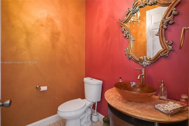 1282 Grant Ct, Hollywood, FL 33019 - half bathroom featuring toilet, vanity, tile patterned flooring, and baseboards