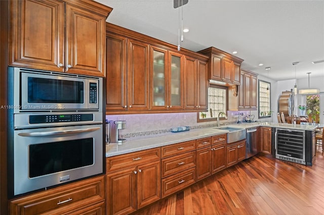 1282 Grant Ct, Hollywood, FL 33019 - kitchen with stainless steel appliances, a sink, beverage cooler, dark wood-type flooring, and brown cabinets