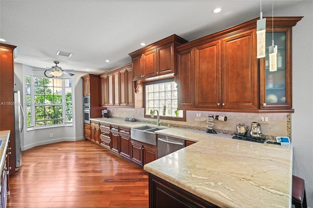 1282 Grant Ct, Hollywood, FL 33019 - kitchen with appliances with stainless steel finishes, a sink, dark wood-style floors, ceiling fan, and backsplash