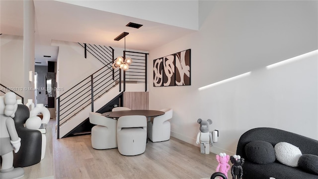 dining space with light wood-type flooring, stairway, and baseboards