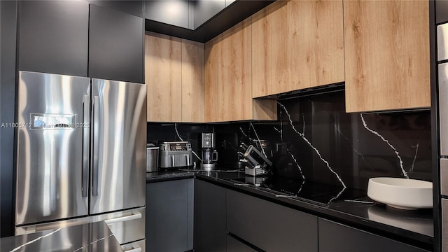 kitchen featuring freestanding refrigerator, dark countertops, modern cabinets, and backsplash